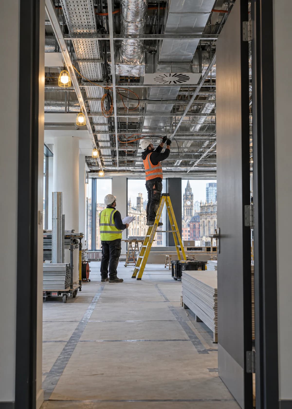 Electricians installing ceiling services during the Stratford office refit